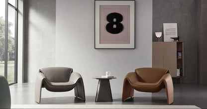Modern interior with two armchairs and a side table in a room with large windows.